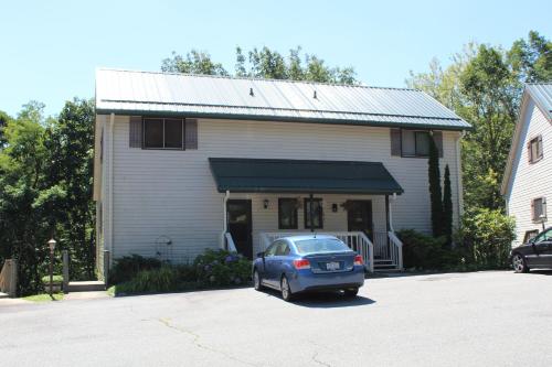 a car parked in a parking lot in front of a house at A Slice of High Country Heaven, Seven Devils Condo in Seven Devils
