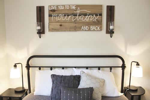 a bedroom with a bed with a wooden sign above it at A Slice of High Country Heaven, Seven Devils Condo in Seven Devils