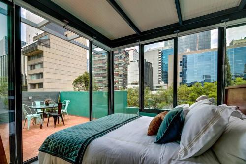 a bedroom with a bed and large glass windows at Mr. W GREAT MODERN-SUNNY PH LUXE oxford 23 mar in Mexico City