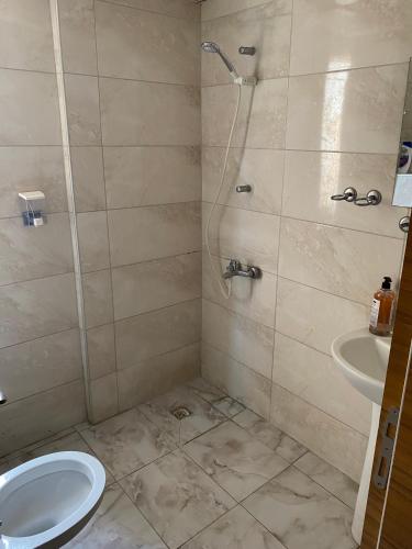a bathroom with a shower and a toilet and a sink at SİES OTEL in Antalya