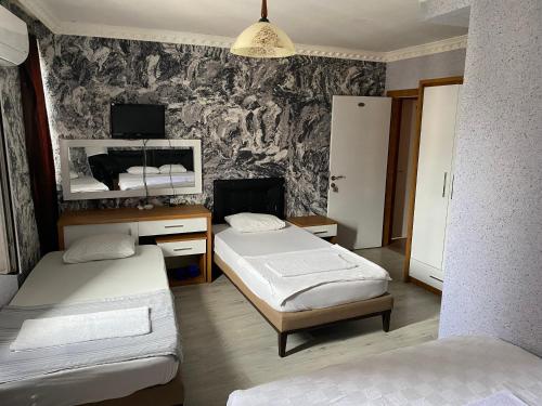 um quarto com 2 camas e uma parede com papel de parede em SİES OTEL em Antalya