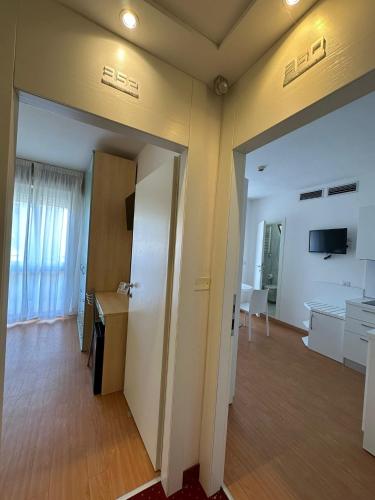an empty room with a door and a room with a table at Hotel Ardea in Riccione