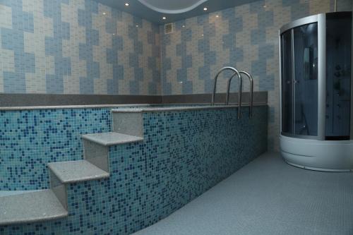 a bathroom with a tub with stairs and a shower at Eriks guest house in Goris