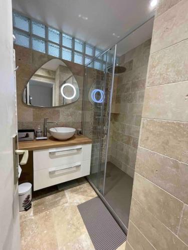 une salle de bain avec douche et lavabo dans l'établissement Appartement bord de mer avec garage, à Menton