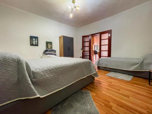 a bedroom with two beds and a wooden floor at Vila Kodra in Tirana