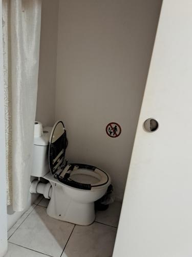 a bathroom with a toilet with a black seat at City Large Studio in Limassol