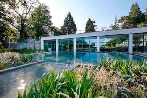 un grand bâtiment avec une piscine devant dans l'établissement Appartement L'Annexe City - 3 étoiles, à Thonon-les-Bains