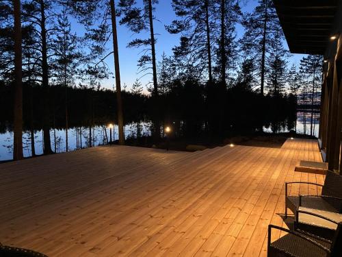 a wooden deck with a view of the water at night at Lakehouse Juolas in Mäntyharju