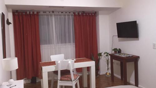 uma sala de estar com uma mesa e uma cortina vermelha em Palermo Botánico em Buenos Aires
