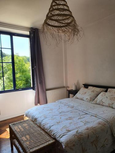 a bedroom with a bed and a large window at Les bords de Rance in Dinan