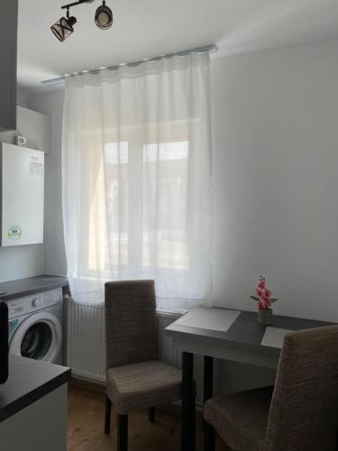 a kitchen with a table and chairs and a window at Studio Tineretului in Zalău