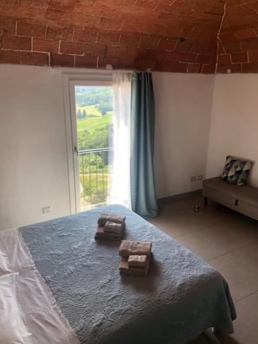 a bedroom with a large bed with a window at La casa di Isola in Peccioli