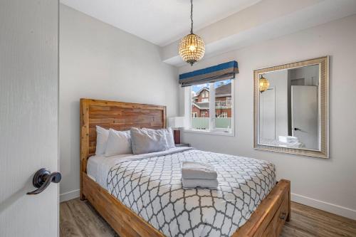 een slaapkamer met een bed en een spiegel bij Newly renovated Blue Sky - Family Fun - 2 Bed -2 Bath in Canmore