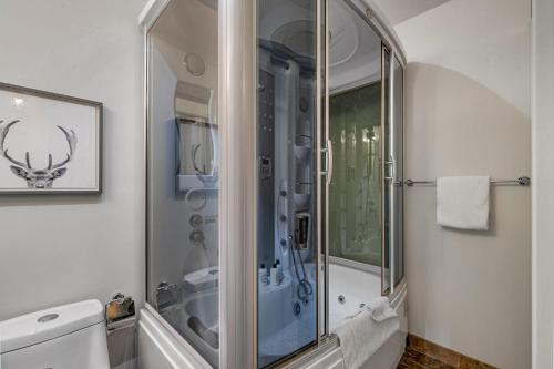 een badkamer met een douche en een glazen deur bij Newly renovated Blue Sky - Family Fun - 2 Bed -2 Bath in Canmore