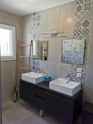 une salle de bain avec deux lavabos et un miroir dans l'établissement Villa moderne sur les hauteurs d'Aramon, à Aramon