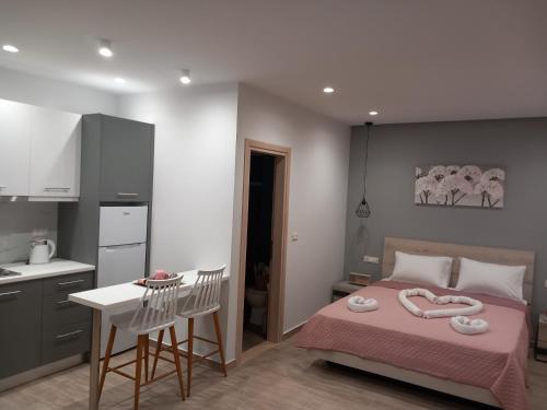 a bedroom with a pink bed and a kitchen at Kolymbia summer holidays in Kolymbia