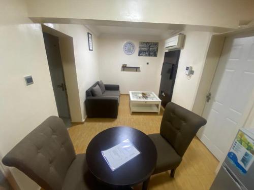 a living room with a table and chairs and a couch at Apartment A- 2 Bedroom Apartment) Hillside Gardens in Lagos