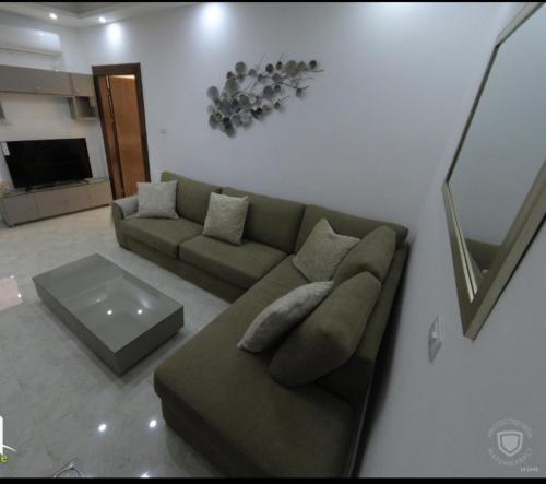 a living room with a couch and a table at Amazing one Bedroom Apartment in Amman Elwebdah 1 in Amman