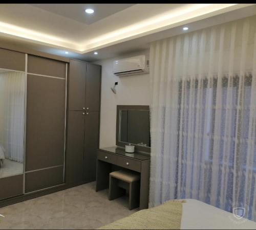 a bedroom with a television and a desk with a bed at Amazing one Bedroom Apartment in Amman Elwebdah 1 in Amman