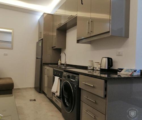 a kitchen with a washer and a dishwasher at Amazing one Bedroom Apartment in Amman Elwebdah 1 in Amman