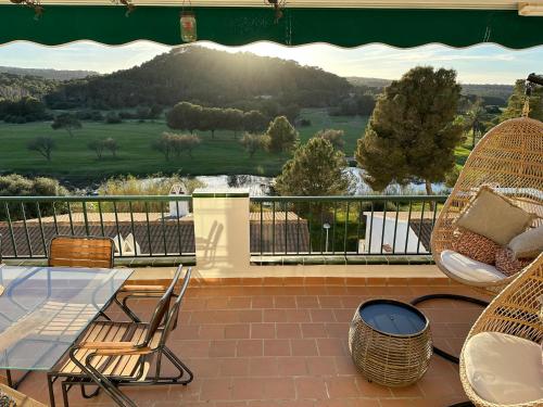 a patio with a glass table and chairs on a balcony at FLAT Surrounded by Nature WIFI & Pool & beach Nearby in Son Parc