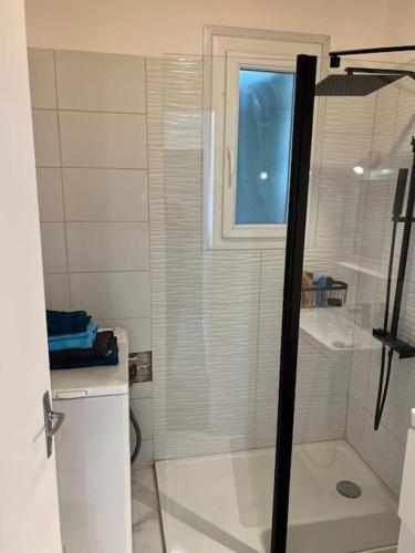 une salle de bain avec une douche avec une porte vitrée dans l'établissement petite maison à 150m de la plage, à Notre-Dame-de-Monts