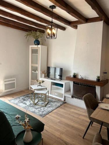 un salon avec une table et une cheminée dans l'établissement petite maison à 150m de la plage, à Notre-Dame-de-Monts