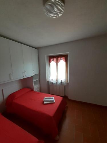 - une chambre avec un lit rouge et une fenêtre dans l'établissement Appartamento Mamy, à Castel San Niccolò