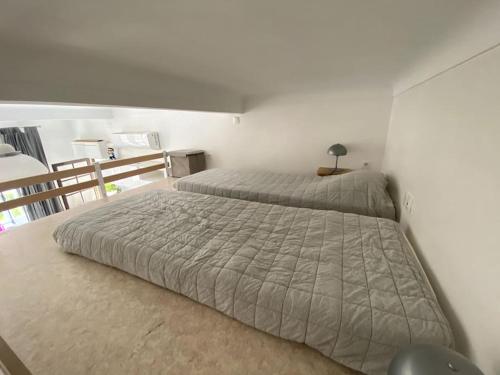 une chambre avec deux lits et une table avec une lampe dans l'établissement Moderne, terrasse et climatisé, Proche plage, spacieux, à Antibes