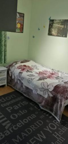 a bed in a room with a blanket on it at Ett-to rom til leie i et privat hus in Brumunddalen