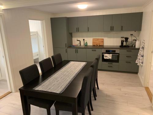 a dining room with a table and chairs in a kitchen at Reistad Ranch in Hidra