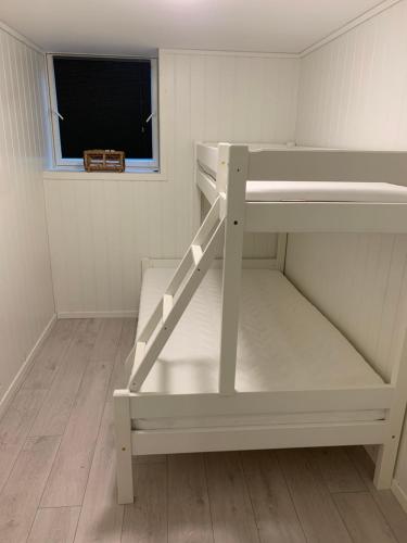białe łóżko piętrowe w pokoju z oknem w obiekcie Reistad Ranch w mieście Hidra