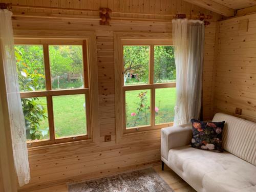 uma sala de estar com duas janelas e um sofá em BUNGALOV em Kemer