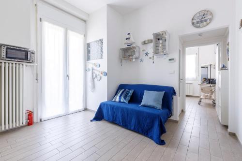 a bedroom with a blue bed in a white room at Sissi's Home [Due Passi Dal Mare, Free WiFi] in Punta Marina