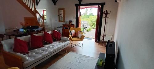 a living room with a white couch with red pillows at The Old Mill, Kilcorkey, Bellanagare, Castlerea, County Roscommon - West of Ireland in Bellanagare
