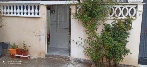 an entrance to a building with a door and plants at residhome in Sétif