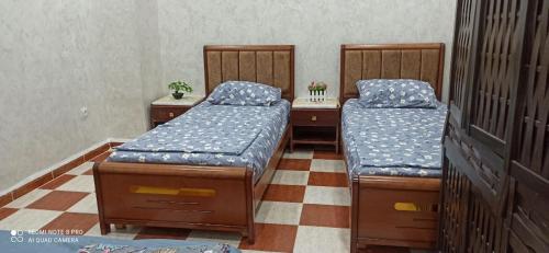 two twin beds in a room with at residhome in Sétif