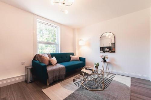 a living room with a blue couch and a mirror at Barite - 1 Bedroom Flat in Reading