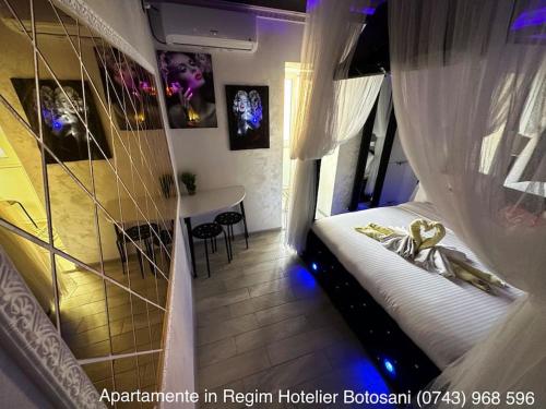 a bedroom with a bed and a table in a room at Apartament cu o camera de Lux cu Jacuzzi/Constelatie complet utilat acceptam plata cu cardul de vacanta in Botoşani