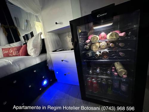 a room with a refrigerator with drinks and a bed at Apartament cu o camera de Lux cu Jacuzzi/Constelatie complet utilat acceptam plata cu cardul de vacanta in Botoşani