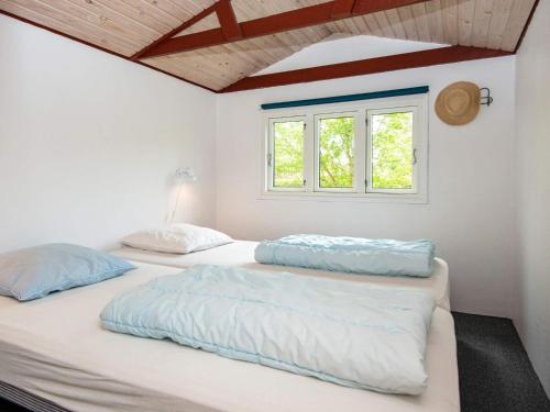two beds in a white room with a window at 6 person holiday home in Juelsminde-By Traum in Sønderby