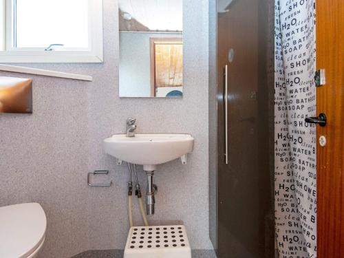 een badkamer met een wastafel, een toilet en een spiegel bij Holiday home Juelsminde XCI in Sønderby