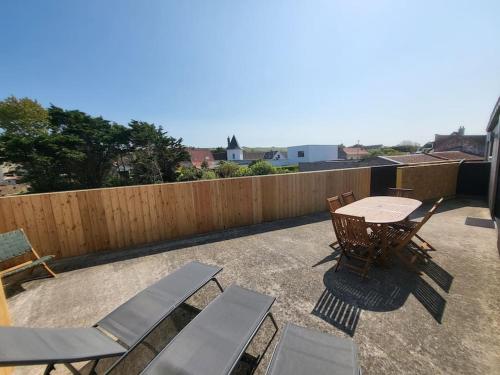 a patio with a table and chairs and a fence at La Terrasse du Sentier in Sangatte