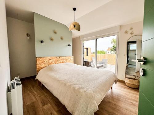 a bedroom with a large bed and a large window at La Terrasse du Sentier in Sangatte