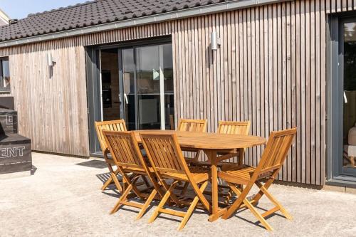a wooden table and chairs on a patio at La Terrasse du Sentier in Sangatte