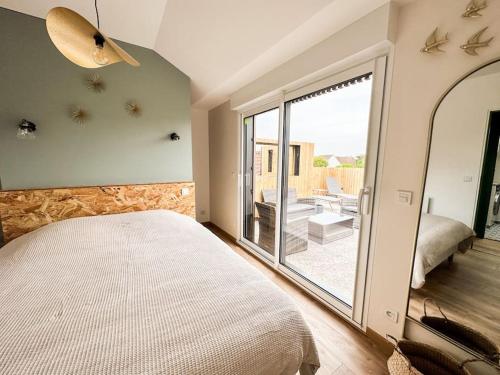 a bedroom with a bed and a large window at La Terrasse du Sentier in Sangatte