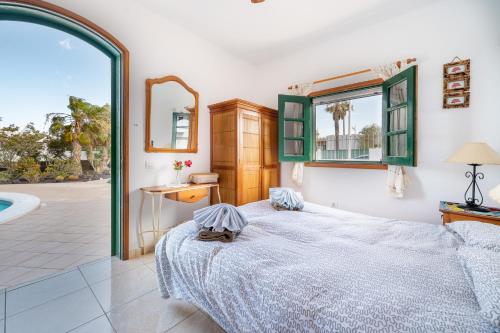 a bedroom with a bed and a swimming pool at Villa Milan in Puerto del Carmen