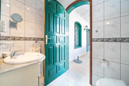 a bathroom with a green door and a sink at Villa Milan in Puerto del Carmen