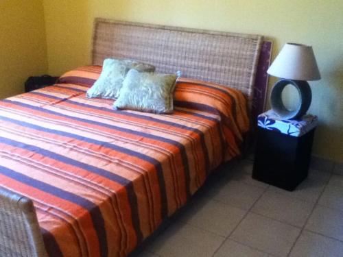 a bedroom with a bed with two pillows and a lamp at Spacious, Sunny, Cozy & Secure in Mindelo