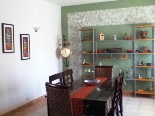 a dining room with a table and chairs and a clock at Spacious, Sunny, Cozy & Secure in Mindelo